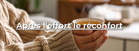 Mains tenant une tasse fumante de thé, personne en pull tricoté beige, ambiance cosy